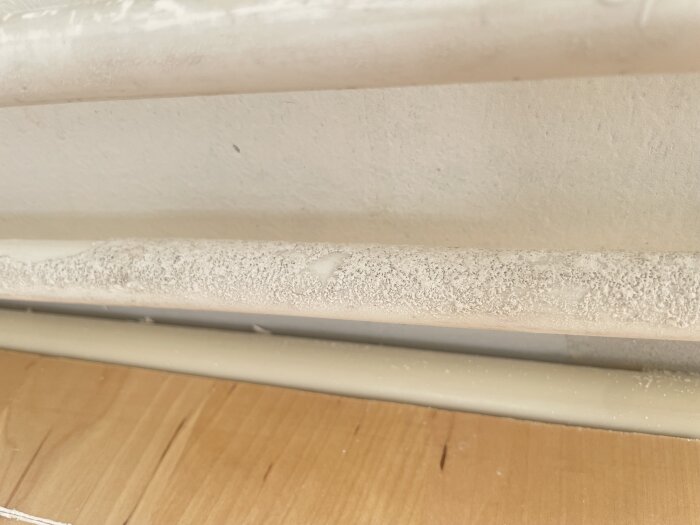 Vitt beläggning på vattenrör, osäker om det är mögel eller torkad färg.