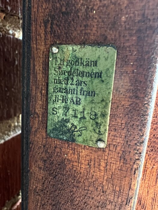 Skylt på en gammal trädörr med texten "Ej godkänt Swedelement med 2 års garanti från JI-TA AB S7118.