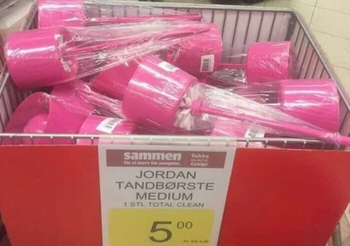 Korg med rosa toalettborstar inplastade, markerade som “Jordan Tandbørste Medium”, säljs för 5 kr styck i en butik.