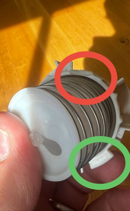 Små piggar på ett plastrulle. Den gröna cirkeln visar en hel pigg, medan den röda visar en bruten pigg.