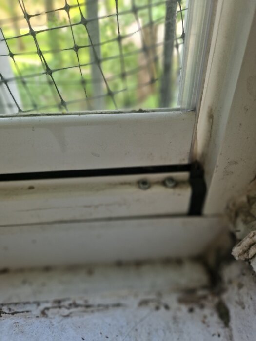 Nika glasdörr detaljer med al-list och skruvar vid det nedre hörnet, del av en justeringsfråga för att fixera en sjunken dörr.