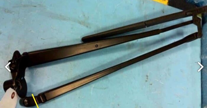 Toyota Ractis vindrutetorkare med två parallella armar, markerad med gult streck där reparation utförts.