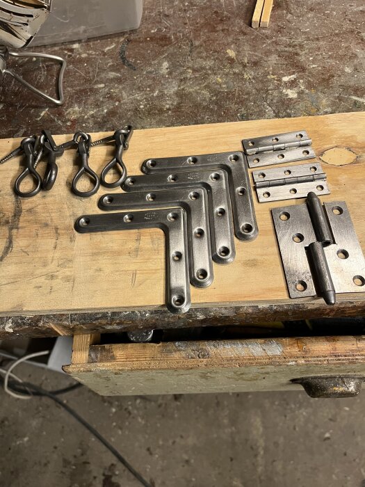 Metallbeslag och gångjärn på en arbetsbänk, rengjorda med citronsyra och planerade för rostskydd med Isotrol.