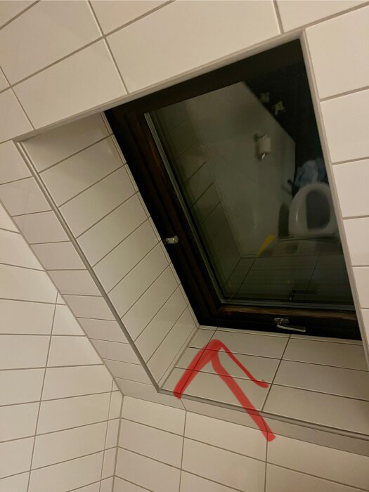 Fönster med vit kakel och en röd markering i högra hörnet visar en otät plats mellan fönstret och karmen.