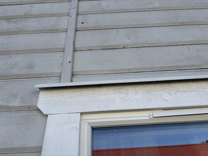 Ulkoseinän puuverhoilu sekä ikkunan yläpuolella oleva koristelista.