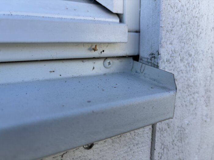 Ikkunalauta ja ulkoseinä, joissa näkyy likaa ja hieman kulumista.