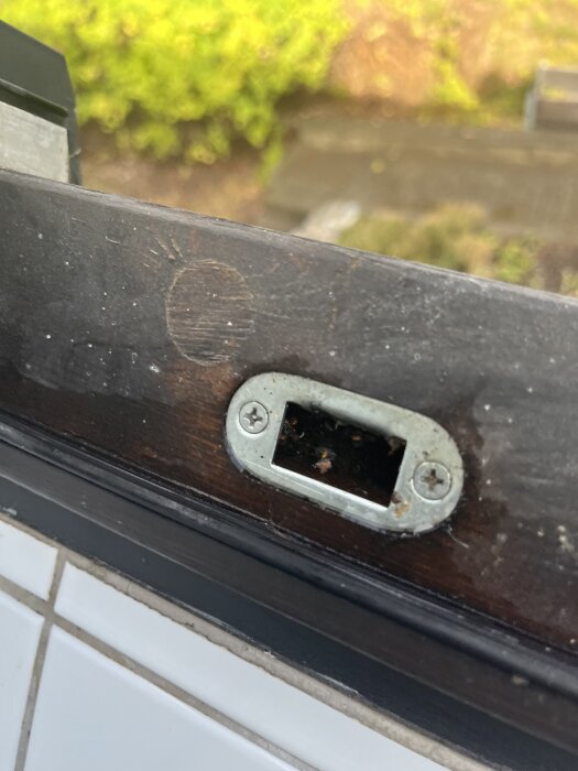 Skadad trälist med metallist, potentiell plats för läckage.