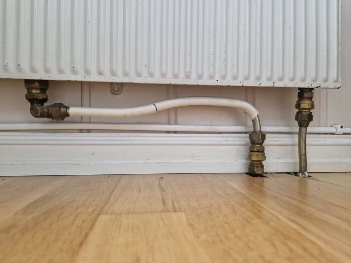 Element med röranslutningar mot vitt golv och vägg.