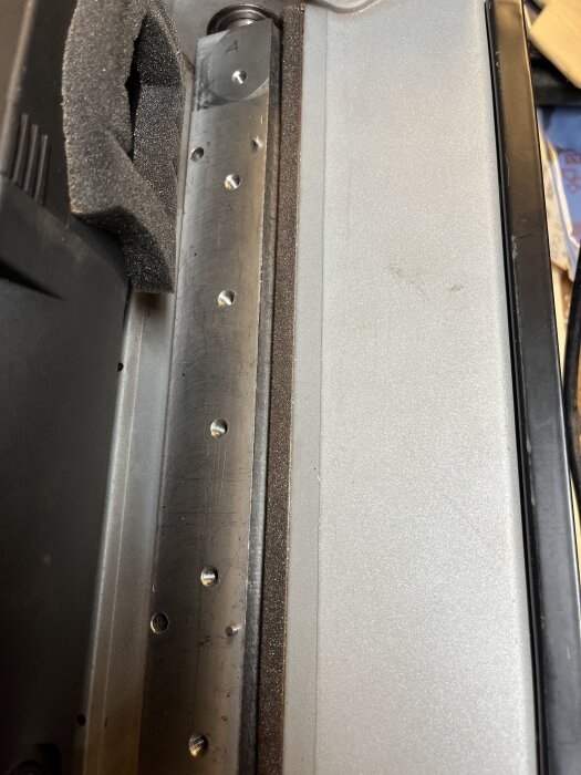 Närbild på en sliten eller skadad kutter från en Triton TPT125, med repor och tecken på användning, sett i en verkstadsmiljö.