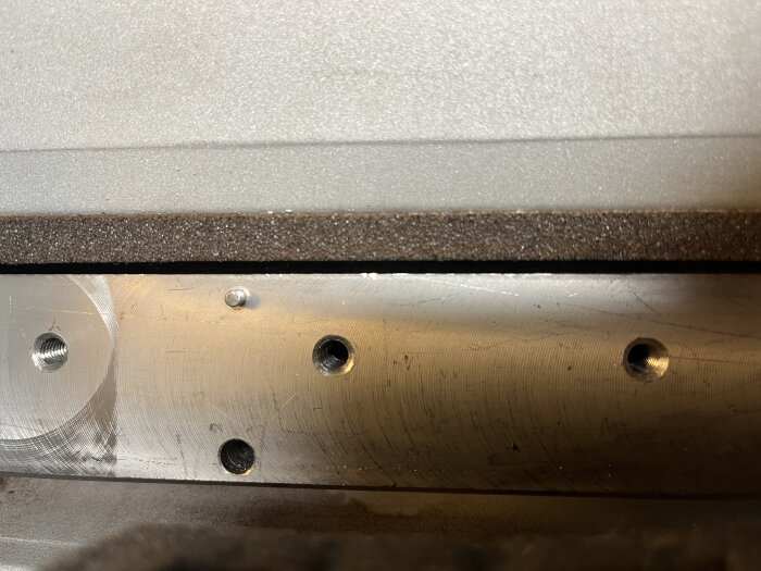 Sliten kutter på en Triton TPT125, visande möjliga skador och slitage på metallytan med flera skruvhål. Frågetecken kring behov av byte.