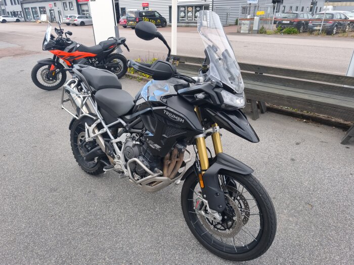 Motorcyklar parkerade på en asfalterad yta utanför en byggnad.