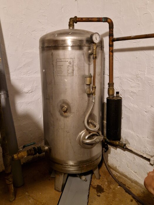 Hydrofor med tryckmätare och kopparrör i källare, diskuteras i forum om lufttrycksproblem och underhåll.