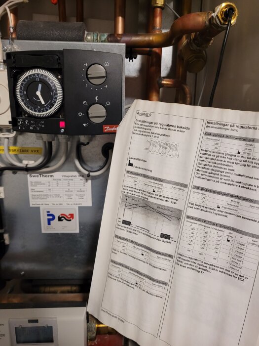 Fjärrvärmeväxlare med manuell timerinställning och cirkulationskontroll, bredvid ett diagram och instruktioner för justering av regulatorn.