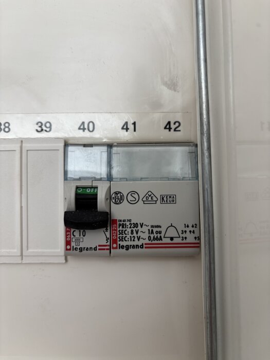 Närbild av en Legrand transformator i elskåpet, visar märkningar med specifikationer som 8 V och 12 V, och primärspänning 230 V, 50/60 Hz.