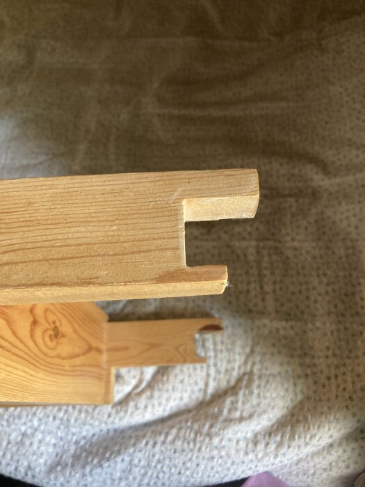 Löstagbar trästege med breda steg, konstruerad för enkel borttagning och användbar i 40 år, visar detaljer av trappstegets infästning.