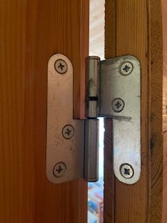 Gångjärn på innerdörr utan justerskruvar eller pigg, fastsatt med fyra skruvar.