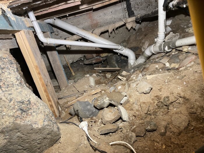 Krypgrund med rörsystem och överblivet byggmaterial under renovering i 1924 års villa.