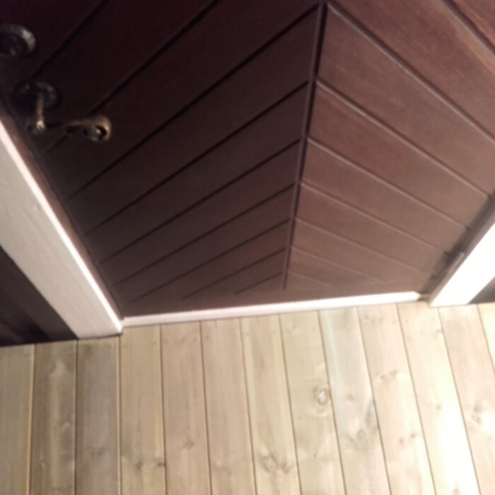 Teakytterdörr från 1975 i gott skick, omgiven av ljusare träpaneler.