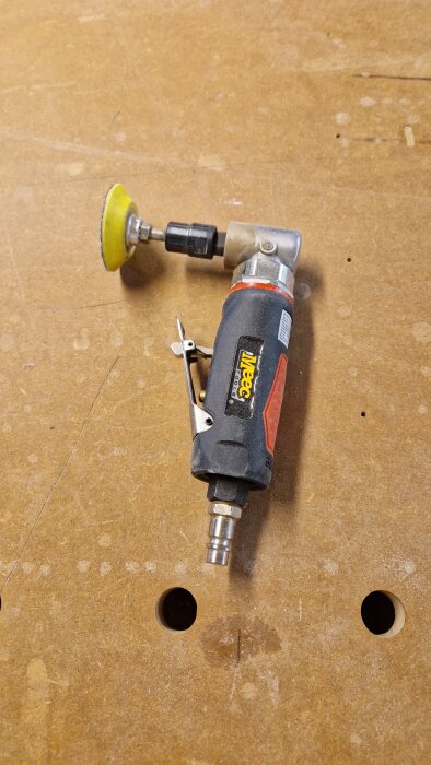 Liten vinkelslipmaskin på träbord, märkt "Meec Tools", med tryckluftsanslutning.