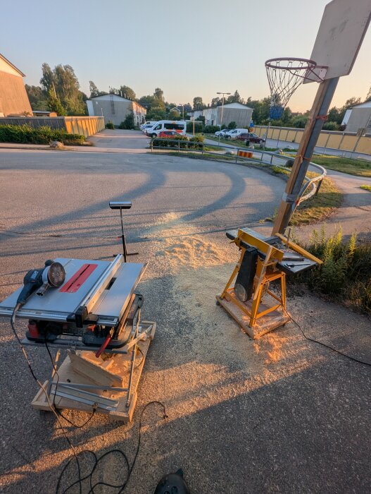 Bordssåg och planhyvel utomhus med sågspån på marken, används för att bearbeta golvplanka efter renoveringens krav.