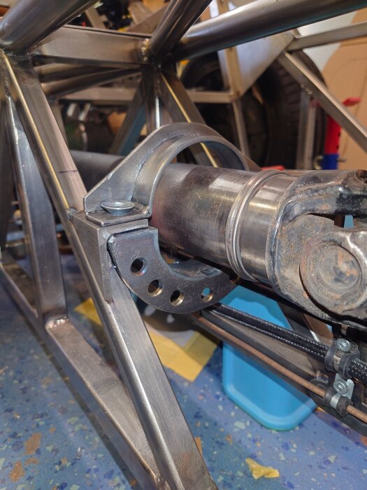 Fångstring för kardanaxel på ett bygge, med svetsade metallramar och ledning.