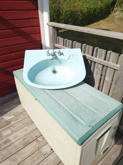 Handfat med kran, placerat på utomhusförvaring. Enligt inlägget är packningen belägen långt under kranen.