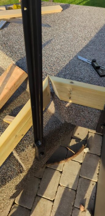 Två brädor ska geras ihop vid ett trappräcke, fotograferade på markplattor med verktyg vid sidan.