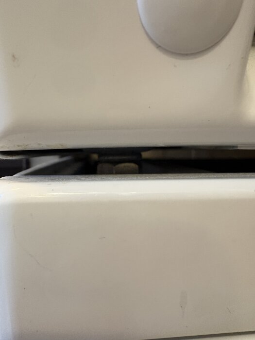 Tätt utrymme mellan två vita maskiner, troligen en torktumlare och tvättmaskin.