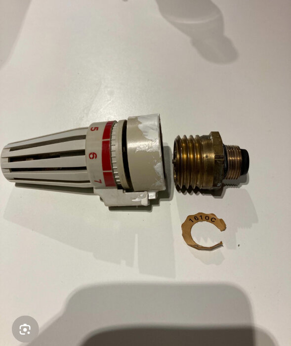 Radiatorventil med termostatreglering och gängad koppling, separat mässingsdel och bricka märkt "1610C".