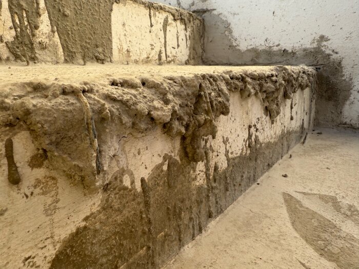 Ofärdig cementgjuten trappa med ojämn yta och synlig armering, arbete avbrutet mitt i processen.