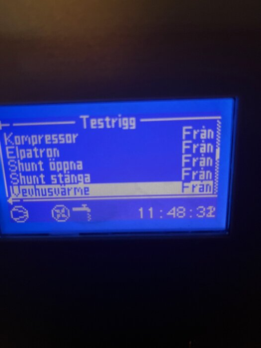 Display på värmepump med texten "Testrigg" och status för komponenter som kompressor, elpatron och shunt visas som "Från".