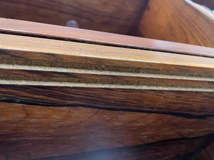 Äldre bokhylla med spår för glasskivor, träpanel och två plastlister för montering.