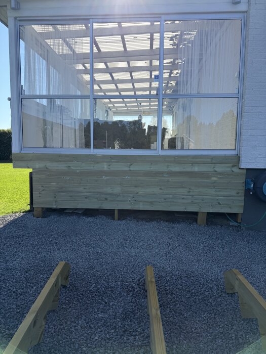 Utomhusbild på en altan med liggande trall, förberedelse för att bygga en trappa. Trallen är 28x120 mm och omger altanens nedre del.