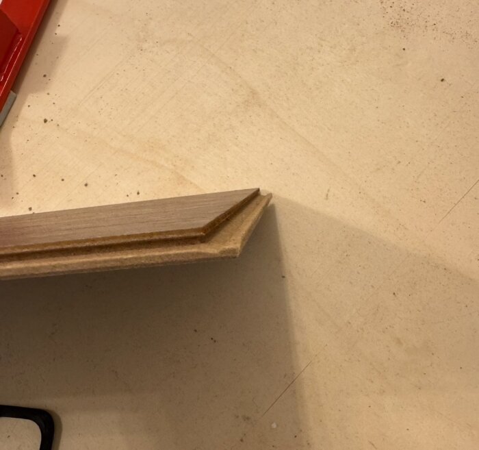 Kortända av logoclic golvbräda som ska sammanfogas, med synlig profilering för sammanfogning.