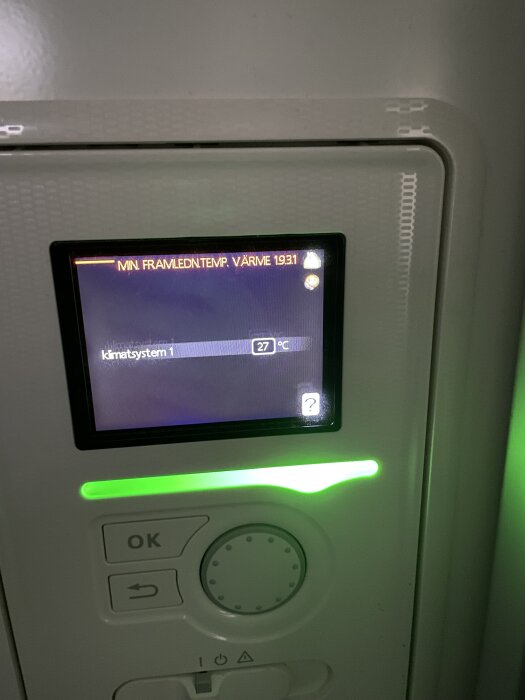 Närbild av en Nibe värmepumps display som visar klimatinställningar med framledningstemperaturen satt till 27°C och grönt ljus.