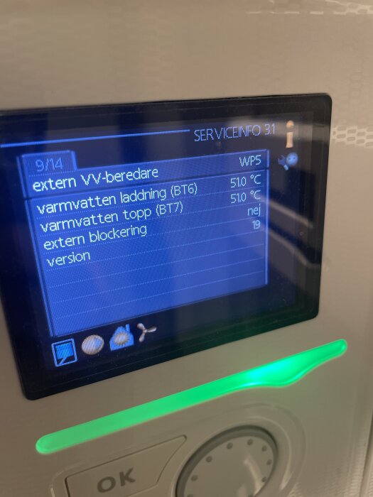 Display på värmepumpens kontrollpanel med temperaturinställningar och serviceinformation för varmvatten i ett hushållssystem.