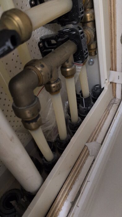 Rörledningar och kopplingar i ett skåp där vatten kommer in i ett badrum, möjligen källa till en sötaktig, otrevlig lukt enligt inlägg.