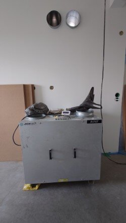 Ventilationsaggregat Acetec A170T installerat i ett teknikrum, omgivande kablar och rör synliga på väggen.