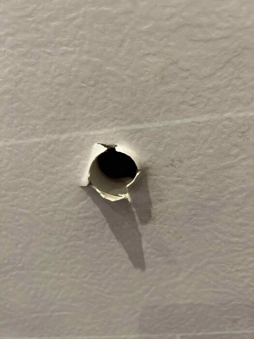 Hål i väggen med trasig kant, cirka 1,5 cm i diameter, där eldragning tidigare förekommit, behöver tätas för att bli vattentätt i duschutrymme.