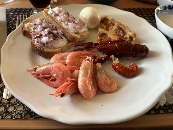 Tallrik med räkor, kräftor, västerbottenpaj, ägg och smörgåsar med rödlök och aioli.