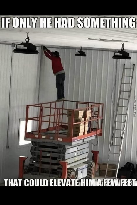 En person står högst upp på en saxlyft med lådor, försöker nå taket i en lagerlokal.