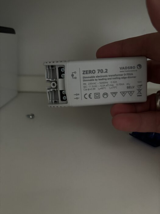 En dimbar transformator märkt "ZERO 70.2" hålls i handen, med synliga kopplingsterminaler.