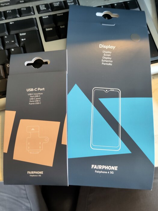 Förpackningar till Fairphone 4 5G med ny skärm och USB-C port på ett tangentbord.