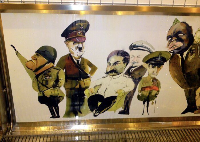 Karikatyrteckning av historiska militärledare i uniform, stående tillsammans mot en vit bakgrund i en monter.