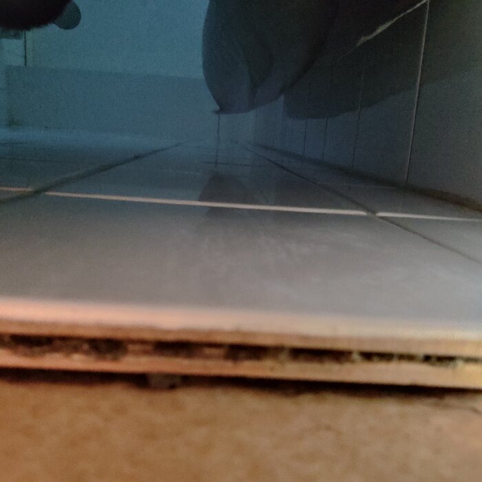 Dubbla lager kakel syns från sidan, med ett mellanrum emellan.