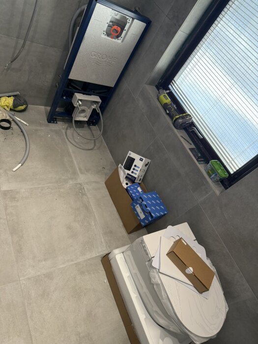Installation av vägghängd toalett och VVS-system i ett badrum under renovering. Verktyg och material ses runt omkring.
