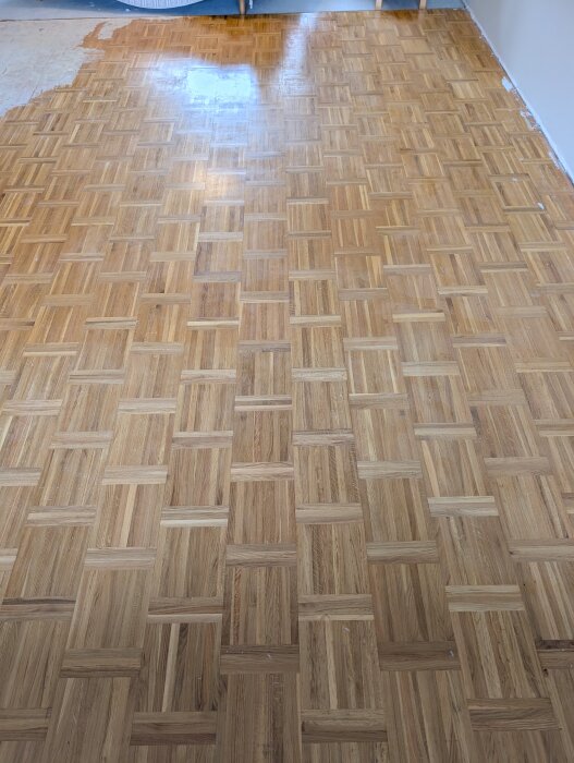 Nyslipat och lackat parkettgolv i rektangulärt mönster.