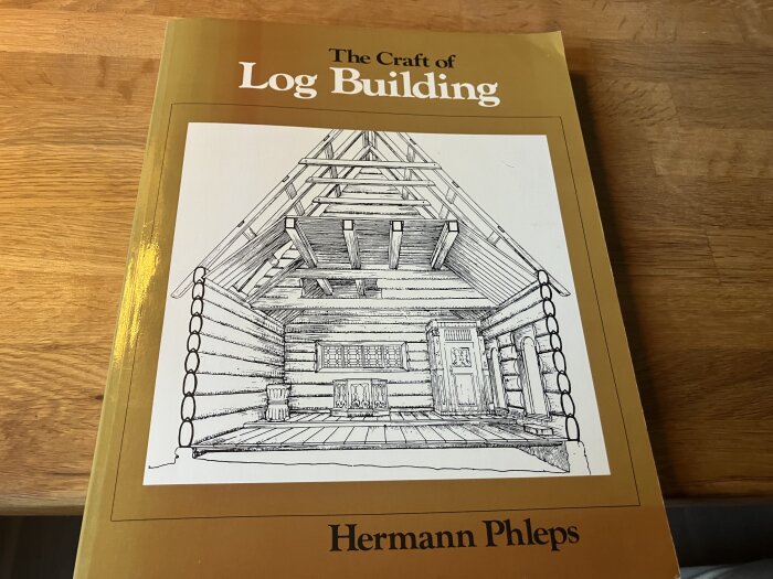 Bokomslag av "The Craft of Log Building" med illustration av timmerstuga.