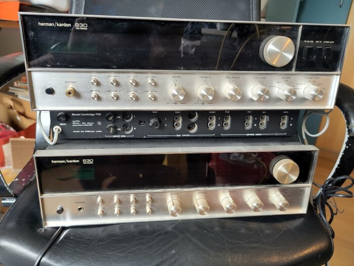 Två Harman/Kardon stereoförstärkare staplade ovanpå varandra, den övre med svart panel och flera rattar synliga.