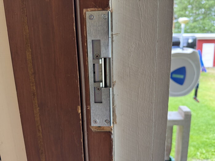Gammal dörr med monterat elsutbleck ASSA Solid14, del av kodlåsinstallation för att göra dörren användbar utan nyckel.